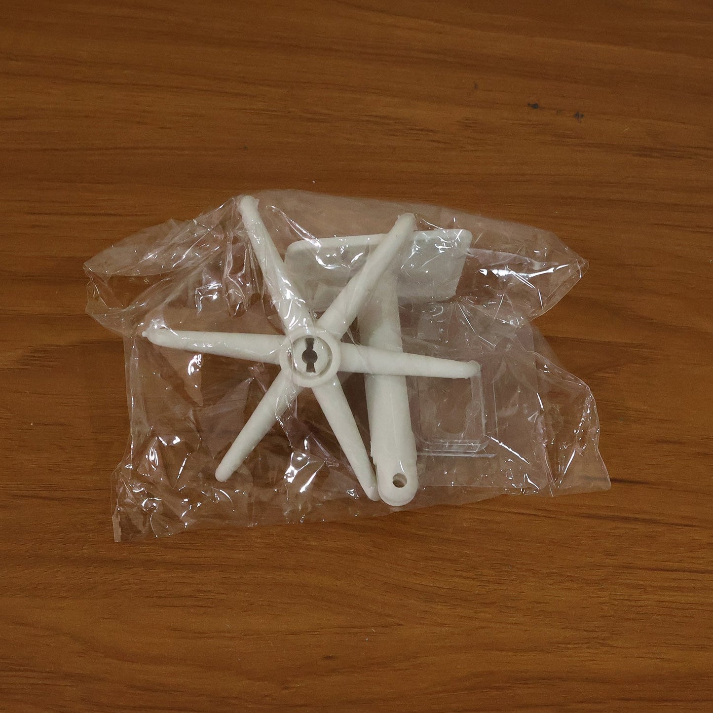 Versatile adhesive hook applied to a glass surface, holding various small items.