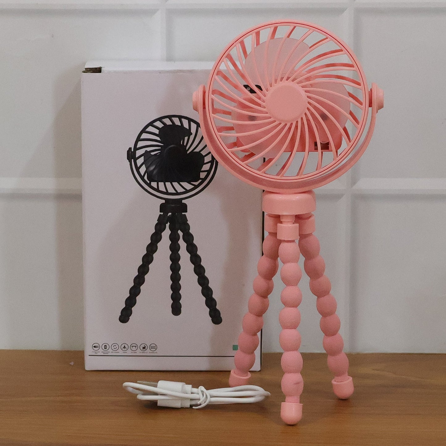 Portable fan with flexible tripod legs wrapped around a metal pole