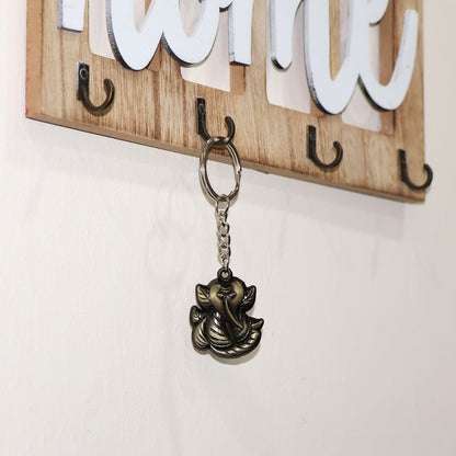 Hand holding Ganesh Face Antique Black Metal Keychain, highlighting portability