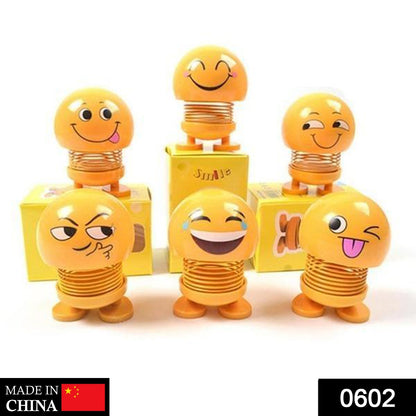 Front view of a funny bobblehead smiling face spring doll for desk decor.