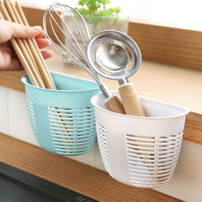 White hanging plastic storage basket mounted on a tiled wall, holding toiletries and soap.