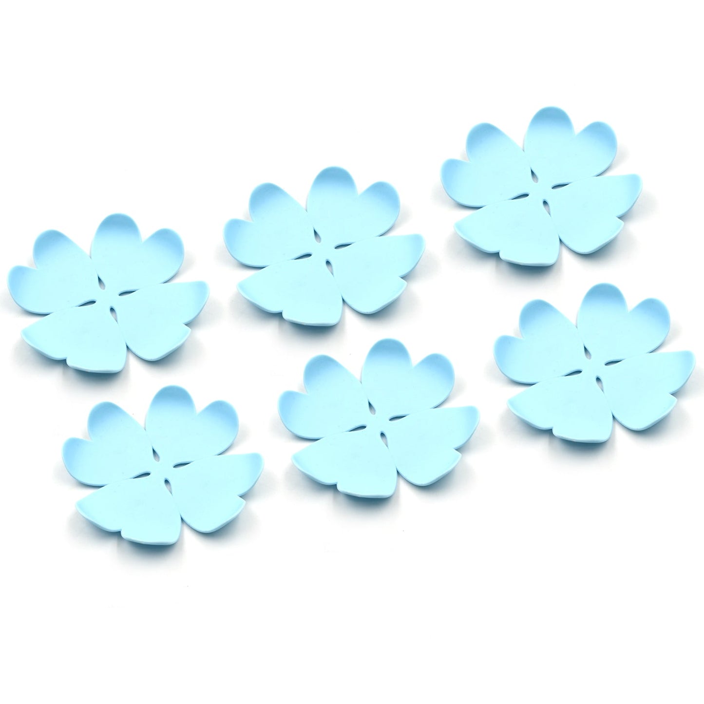Assorted plastic heat resistant coasters in various designs, neatly arranged on a modern dining table.