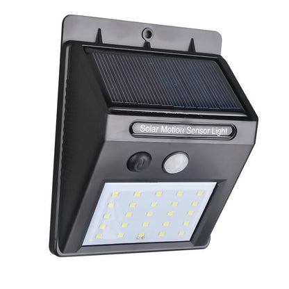 Black solar LED light with motion sensor on a brick wall for outdoor security.