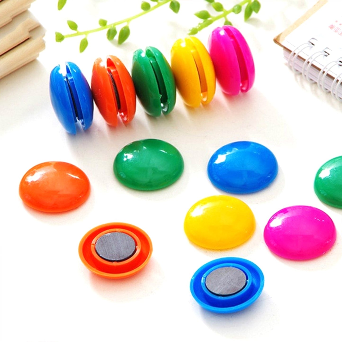 Circular board magnets in assorted colors displayed on a surface.