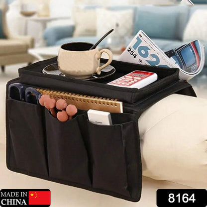 Sofa armrest organizer in black, holding magazines, remotes, and a phone.