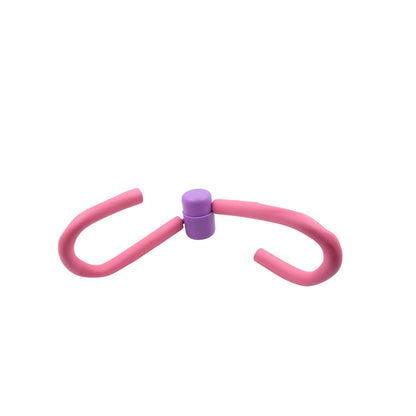 The Thigh Toner positioned next to other gym equipment, highlighting its compact size.
