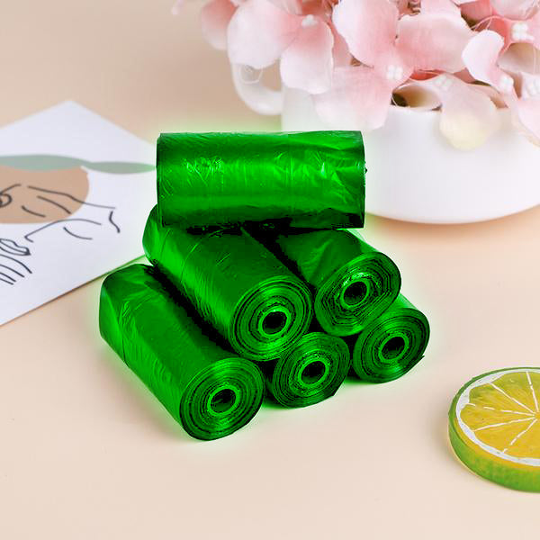 Rolls of green biodegradable garbage bags ready for eco-friendly household waste disposal.
